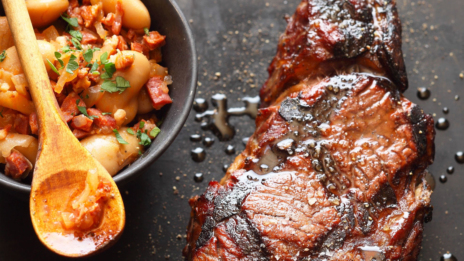  Ein Entrecôte Double (Doppeltes Rumpsteak) in pfiffiger Malzbier-Marinade auf pikanten Chorizo-Bohnen, dazu Kartoffelgratin und Brezel-Serviettenknödel vom Grill


